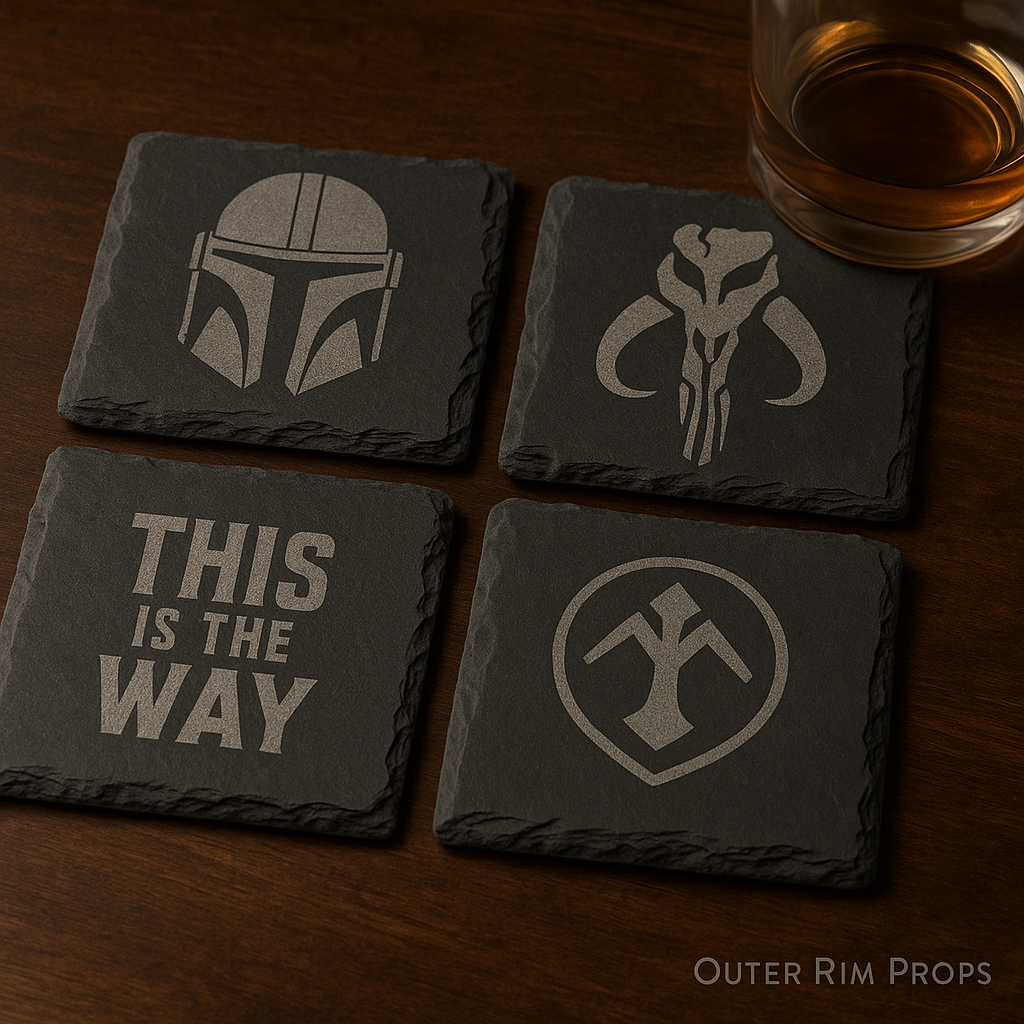 Mandalorian slate coasters on a rustic wood table with engraved helmet and crest designs next to a whiskey glass – Outer Rim Props.”
