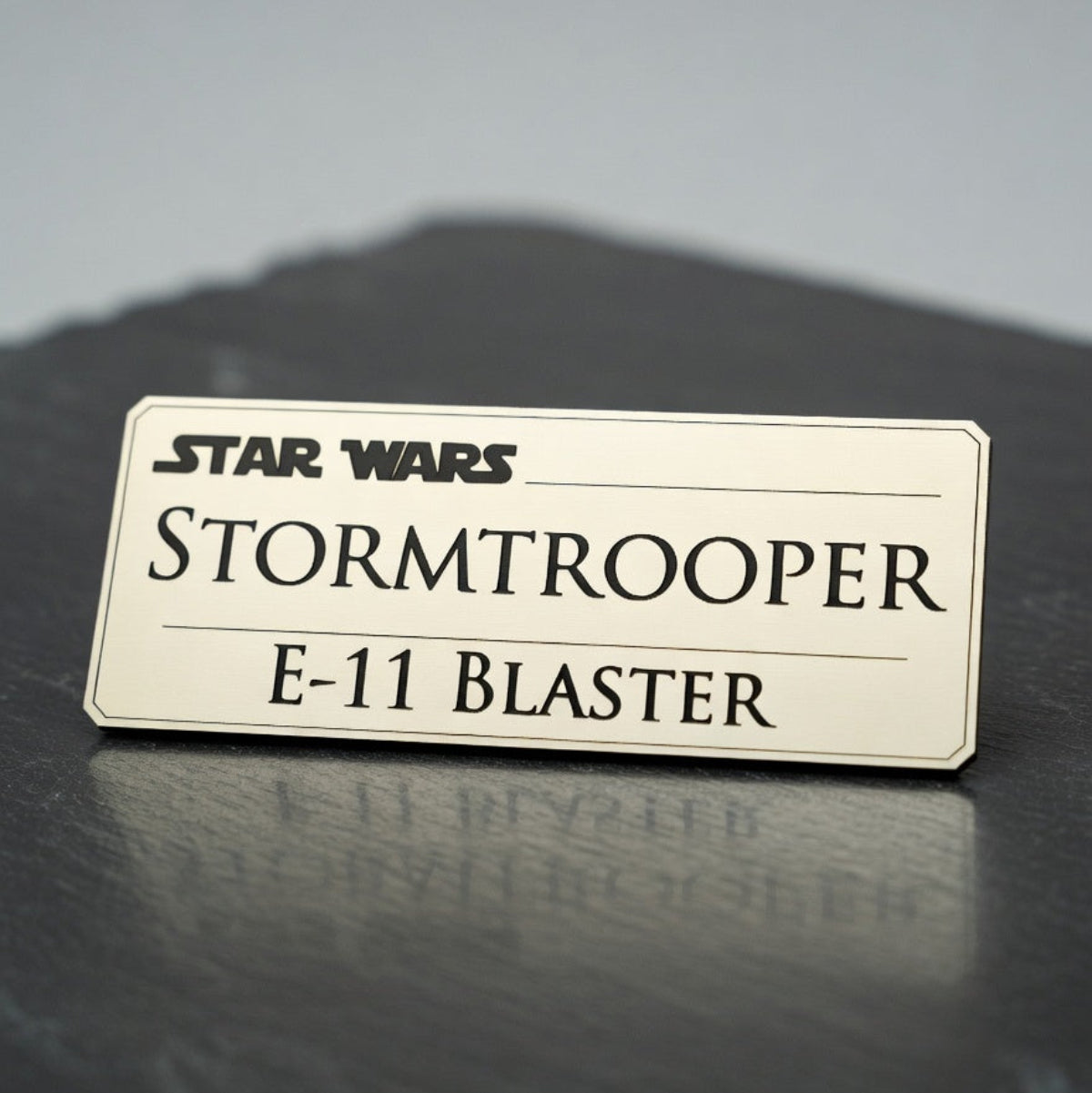 Laser-engraved Star Wars character edition display nameplate on a dark display surface, Outer Rim Props